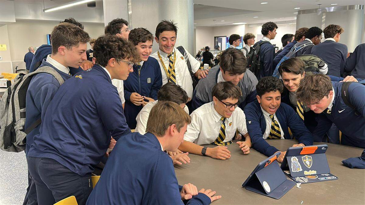 Estudiantes de la Escuela Preparatoria Jesuita de Belén miran en iPads durante el almuerzo mientras se anuncia el próximo Papa católico desde el Vaticano en Roma.