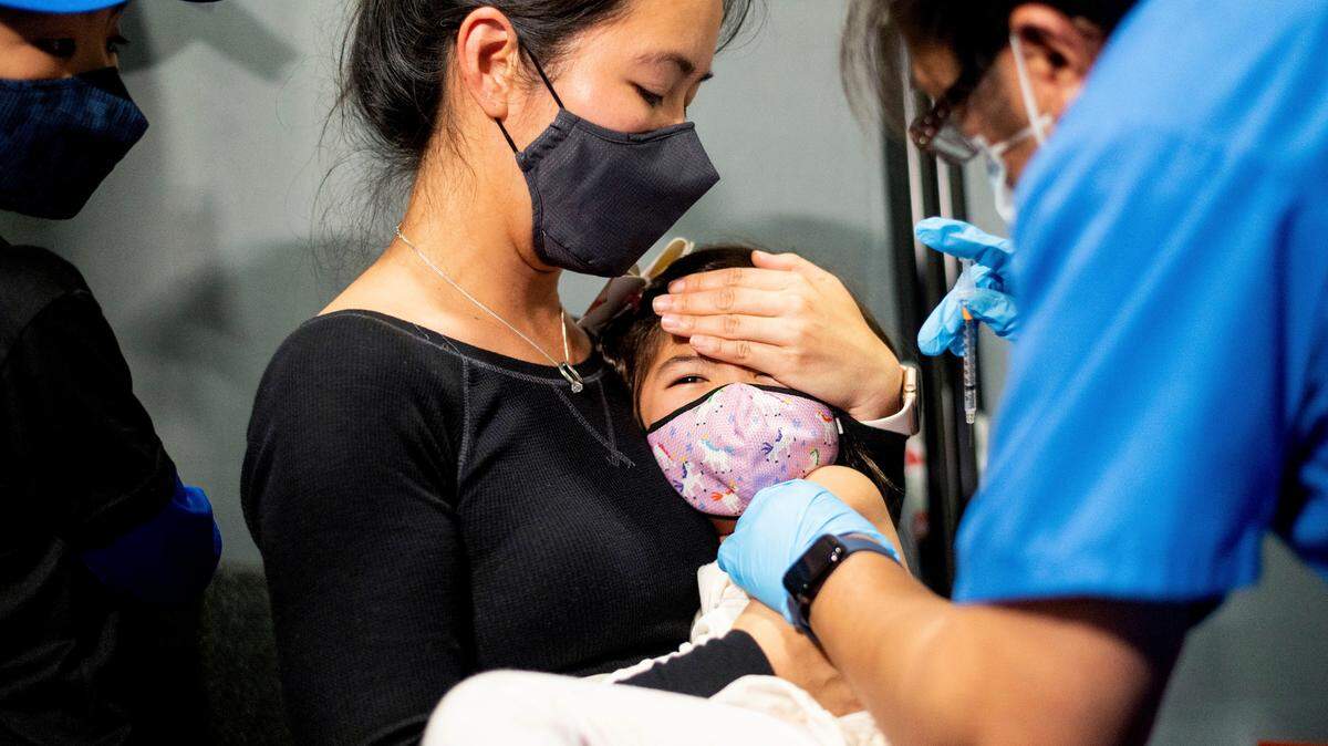 In this stock photo, Christina Yep holds daughter Ariel Yep, 5, as she receives a Pfizer-BioNTech COVID-19 vaccine in San Jose, Calif., on Wednesday, Nov. 3, 2021.