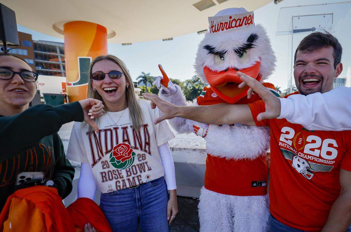 Canes fans Lillian Rekhtman, mascot Sebastian the Ibis, and Austin Decoster, react as Indiana Hoosiers fan Morgan Vidal wears her Indiana Rose Bowl shirt during a UM campus pep rally.