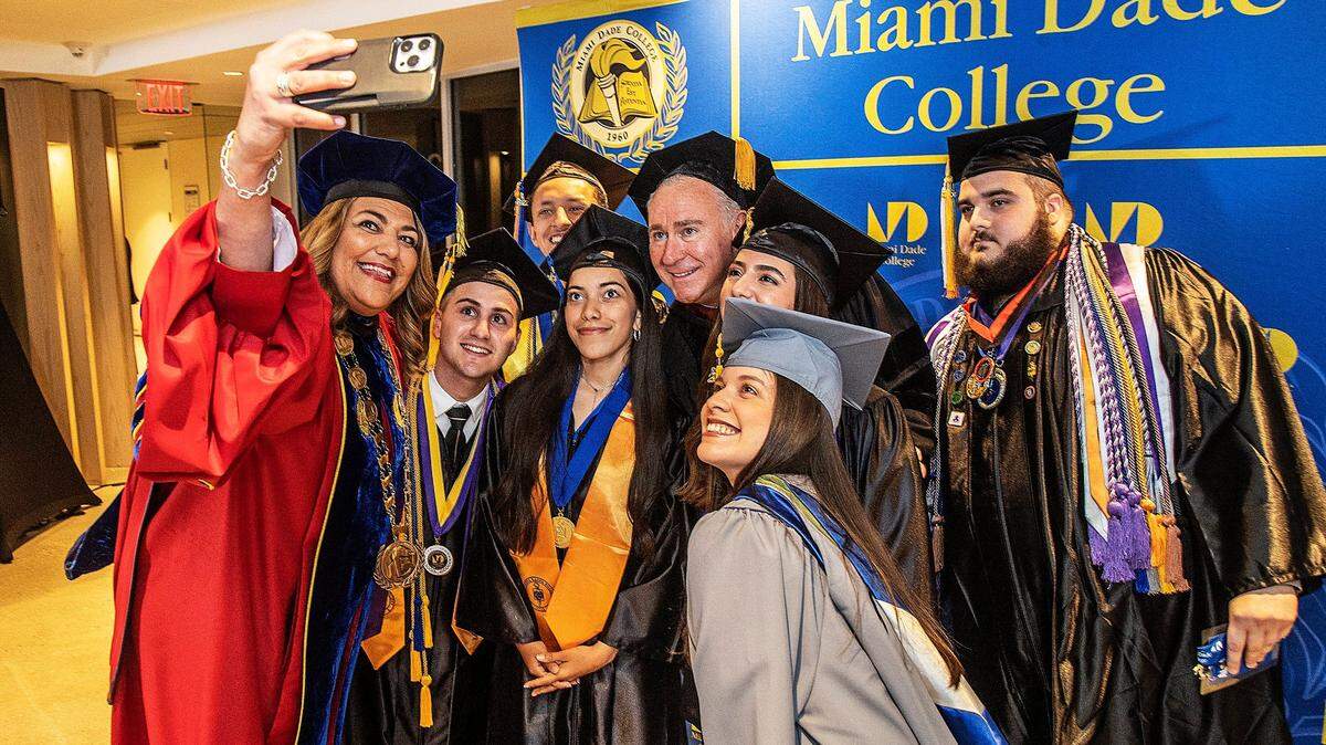 LA PRESIDENTA de Miami Dade College, Madeline Pumariega, se toma una selfie con el fundador y director ejecutivo de Citadel, Ken Griffin, y un grupo de estudiantes universitarios con honores durante la ceremonia de graduación en el LoanDepot Park el sábado 22 de abril de 2023. Griffin anunció una donación de $20 millones al MDC para establecer el Fondo de Becas Griffin, que acelerará nuestra misión de garantizar que cada estudiante tenga un camino hacia la movilidad económica.
