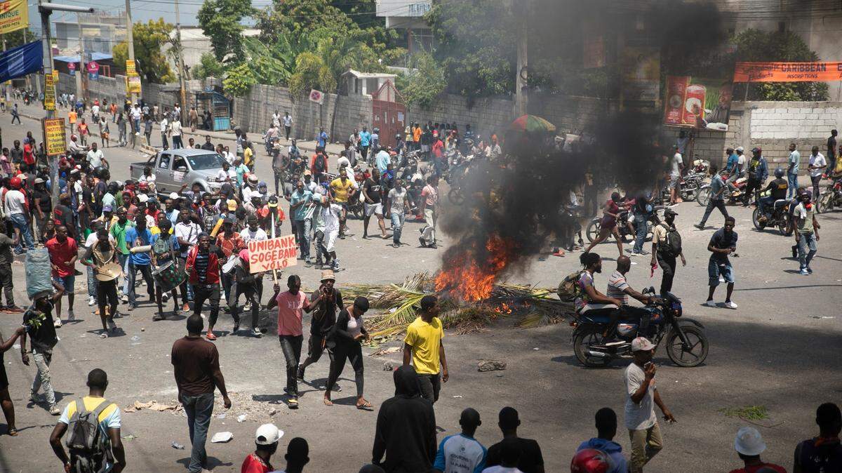 Haitians make their way around burning tires during a protest to demand that Prime Minister Ariel Henry step down. It happened in Port-au-Prince, Haiti, Wednesday, Sept. 7, 2022.