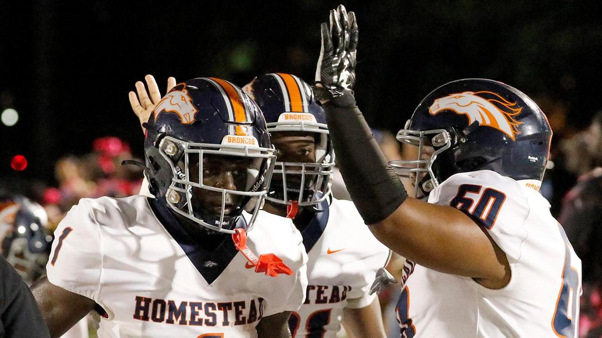 Homestead Broncos players congratulate running back Isaac Brown (1) after he scored a touchdown against Columbus Explorers on Saturday, October 07, 2023 at Tropical Park Stadium in Miami.