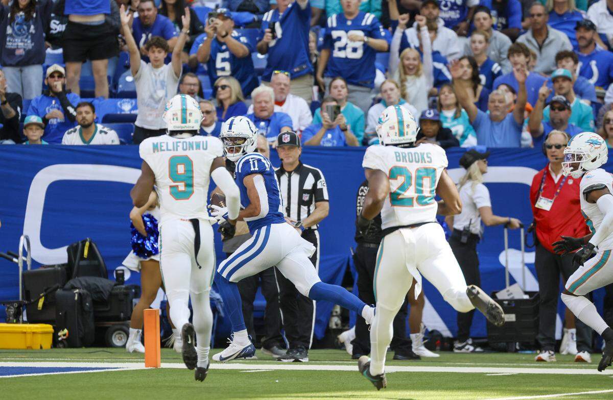 Indianapolis Colts wide receiver Michael Pittman Jr. (11) runs for a touchdown as Miami Dolphins safety Ifeatu Melifonwu (9) and linebacker Jordyn Brooks (20) give chase during the first half of an NFL game at Lucas Oil Stadium on Sunday, September 7, 2025 Indianapolis, Indiana.
