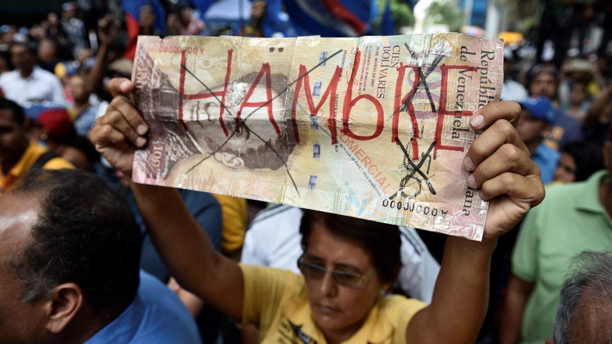 A woman taking part in May anti-Maduro protests in Venezuela holds a sign that says “hambre,” or, in English, “hungry.”