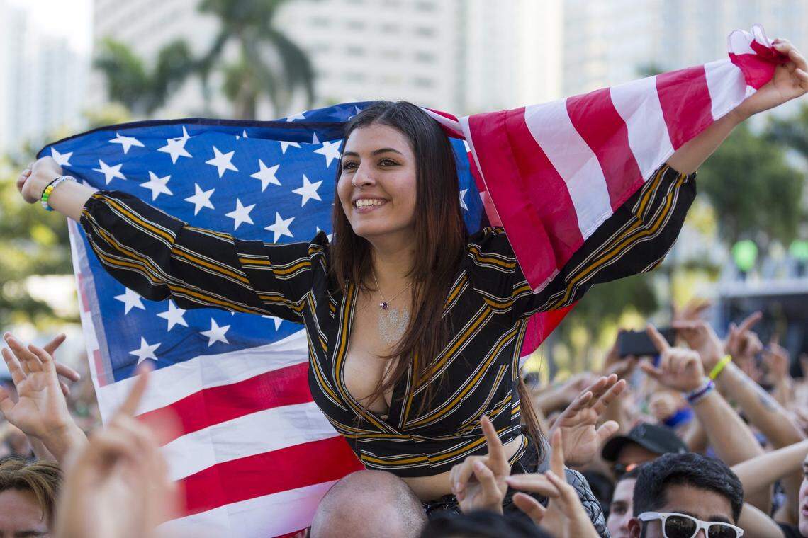 You should fully expect to see young women borrowing a strong pair of shoulders to sit on. Let’s face it, there are a lot of people here. This guest took a seat with a flag on the first day of Ultra Music Festival in Bayfront Park in 2018.