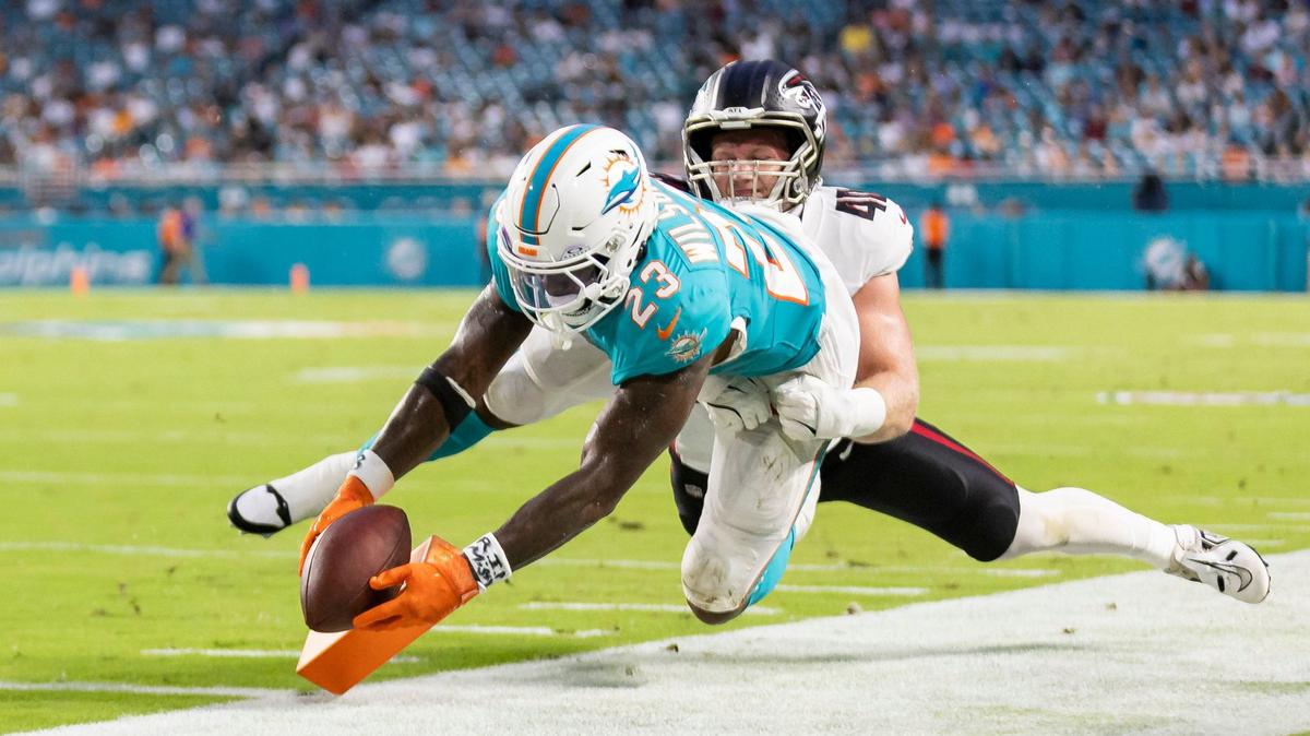 Miami Dolphins running back Jeff Wilson Jr. (23) scores a touchdown as Atlanta Falcons linebacker JD Bertrand (40) tries to defend in the second quarter of their NFL pre-season football game at Hard Rock Stadium on Friday, Aug. 9, 2024, in Miami Gardens, Fla.