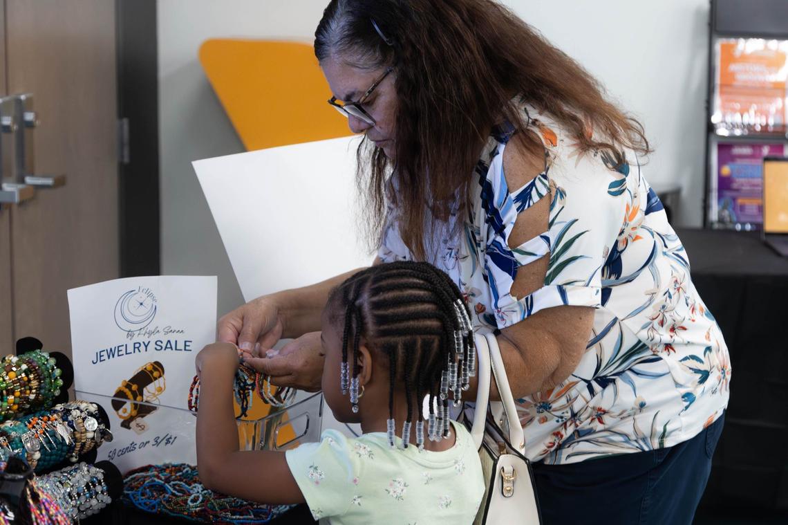 Ouida Purchas and her granddaughter Gianna Gelin look through bracelets at student designer Khyla Sanaa’s jewelry stand before the South Florida Fashion Academy’s Second Annual Student Fashion Show at the L.A. Lee YMCA/Mizell Community Center on Friday, June 7, 2024, in Fort Lauderdale, Florida.
