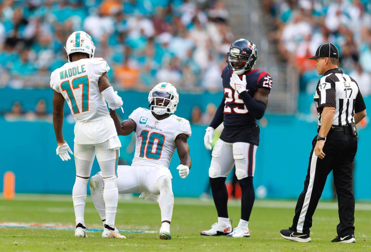 Miami Dolphins wide receiver Jaylen Waddle (17) help teammate Dolphins wide receiver Tyreek Hill (10) after a play during second quarter of an NFL football game against the Houston Texans at Hard Rock Stadium on Sunday, November 27, 2022 in Miami Gardens, Florida.