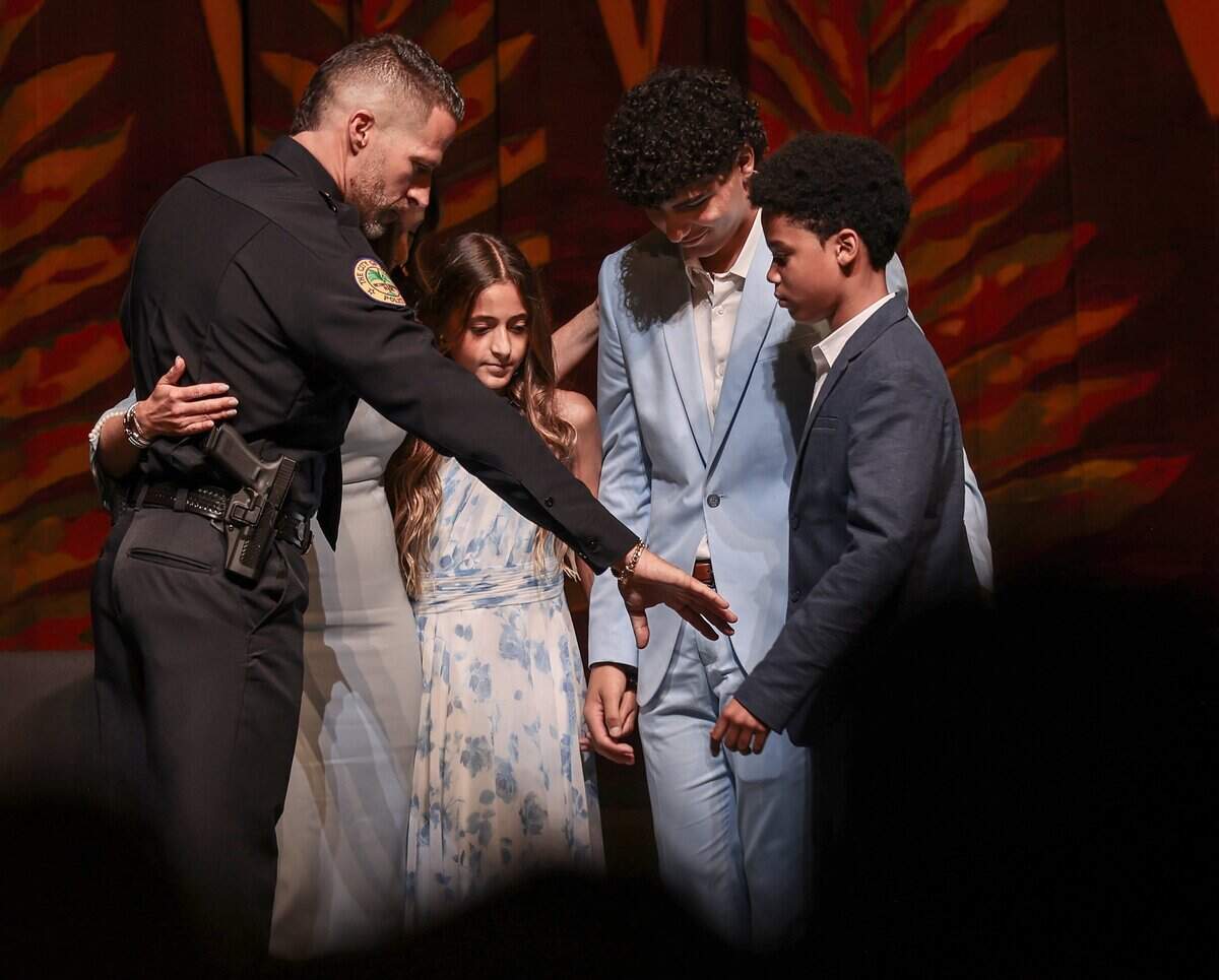 Miami Police Chief Edwin Lopez extends his hand Lucas Alvarez-Upegui, right, as an invitation to join him and his family in prayer. Chief Lopez took the oath of office during his swearing-in ceremony at the Ziff Ballet Opera House on Tuesday, June 16, 2026, in Miami. Lopez was joined by city officials, family members and community leaders as he formally assumed leadership of the department. The ceremony marked a new chapter for the city’s police force.