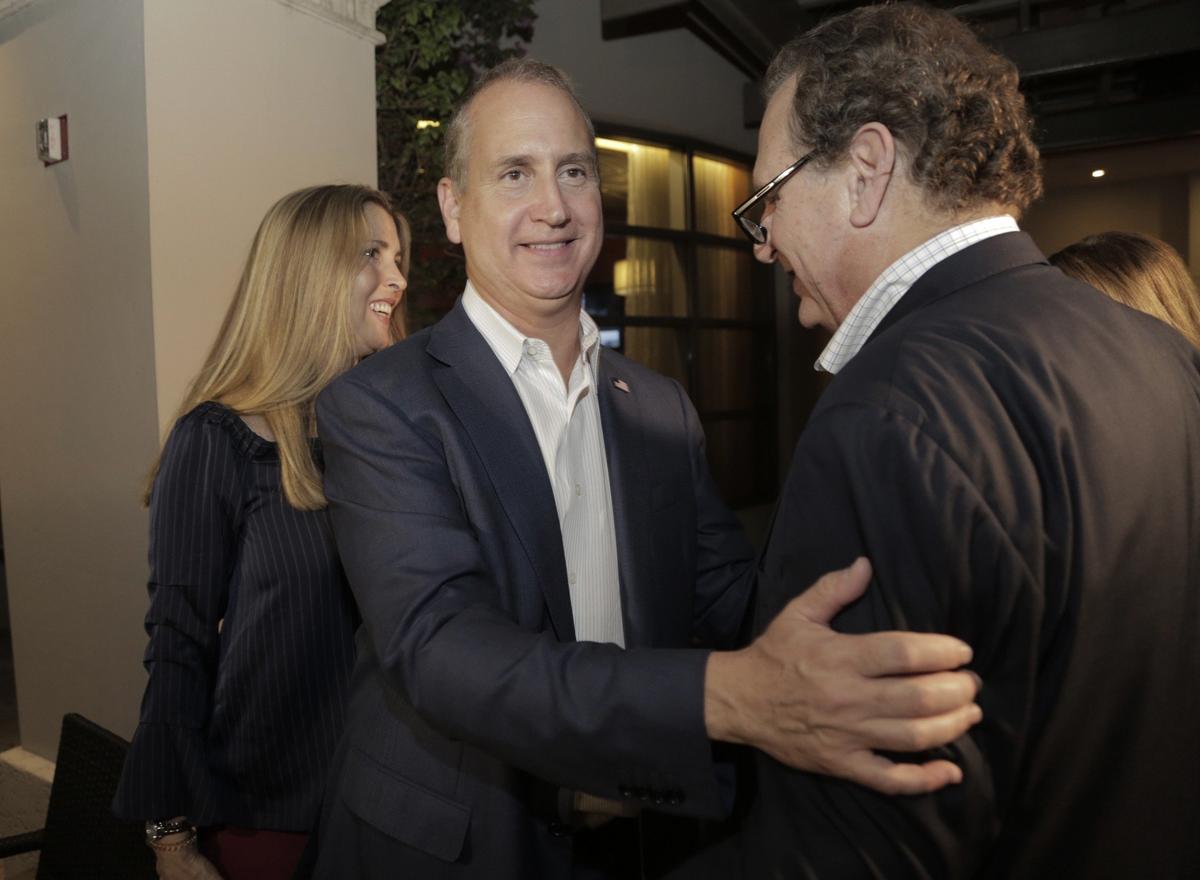 Congressman Mario Diaz-Balart is greeted by his brother Lincoln Diaz-Balart as his wife, Tia, left, also greets well-wishers during a victory party at the Flamingo Terrace at Hialeah Park in Hialeah. Diaz-Balart defeated Democrat Mary Barzee Flores on Nov. 6, 2018, to retain his District 25 seat.