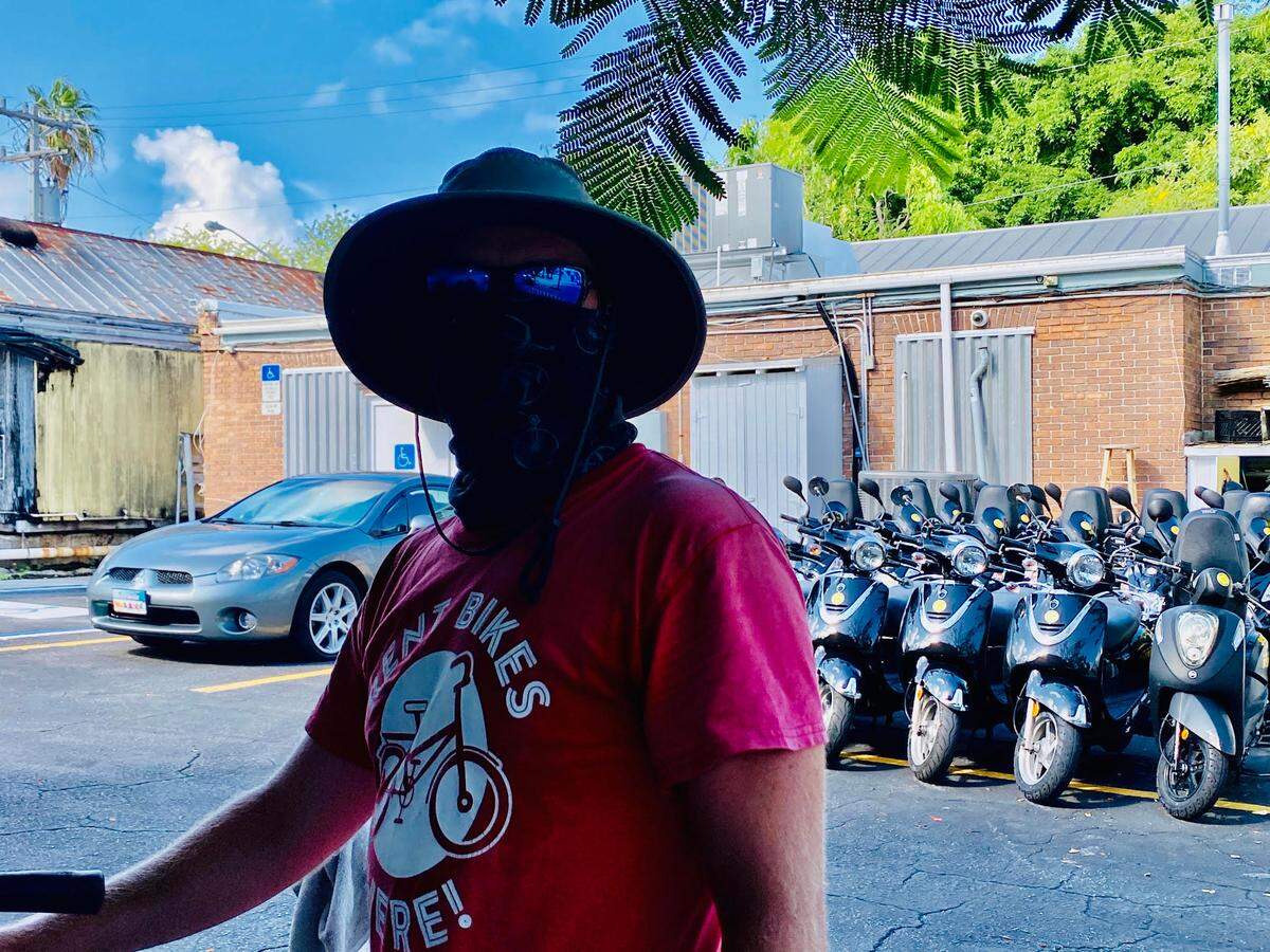 Eddy Muska wears a facial covering while he works outside at a rental shop on Duval Street on July 16, 2020.
