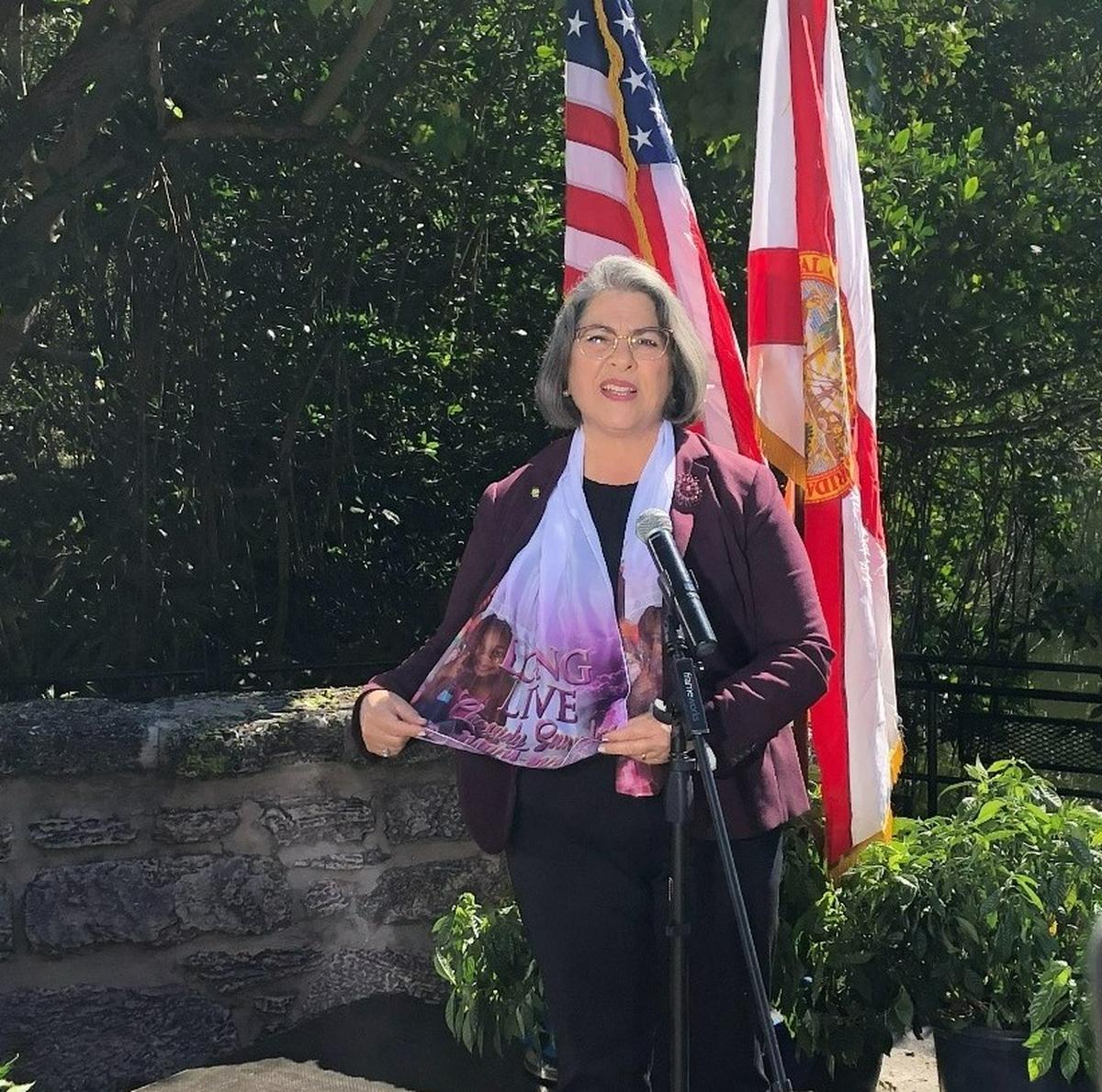 Miami-Dade County Mayor Daniella Levine Cava holds a scarf honoring Chassidy Saunders, 6, who was killed in a drive-by shooting in Miami on Jan. 16, 2021. Levine Cava wore the scarf during her State of the County address on Jan. 31, 2022.