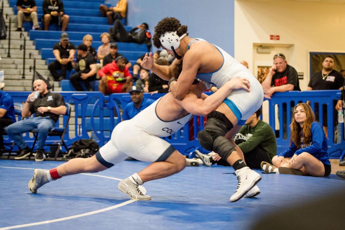 Homestead, February 3, 2024 - Joshua Aviles of south Dade and Zachary Ruiz of Christoper Columbus HS battle it out in the 150 lbs class.