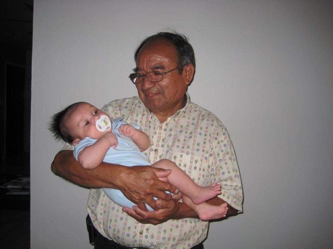 Luis Alpiste, 79, holding one of his grandchildren. Alpiste died of COVID-19 on March 24.