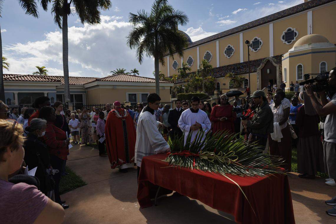 People reflect during the traditional blessing of the palms outside the cathedral before Palm Sunday Mass on Sunday, March 29, 2026, at the Cathedral of St. Mary in Miami, Fla. 