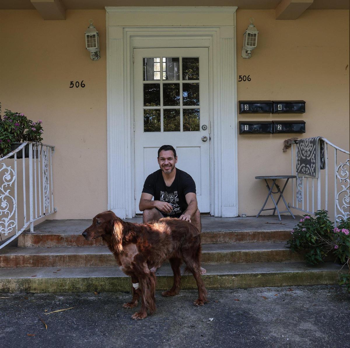 Giancarlo Messina sentado con su setter irlandés, Simona, a la entrada del edificio de Coral Gables donde alquila un apartamento desde hace ocho años. El edificio es uno de los 13 pequeños edificios de apartamentos y dúplex asequibles y antiguos que cubren una manzana completa de la ciudad y que serán demolidos para dar paso a una urbanización de lujo.