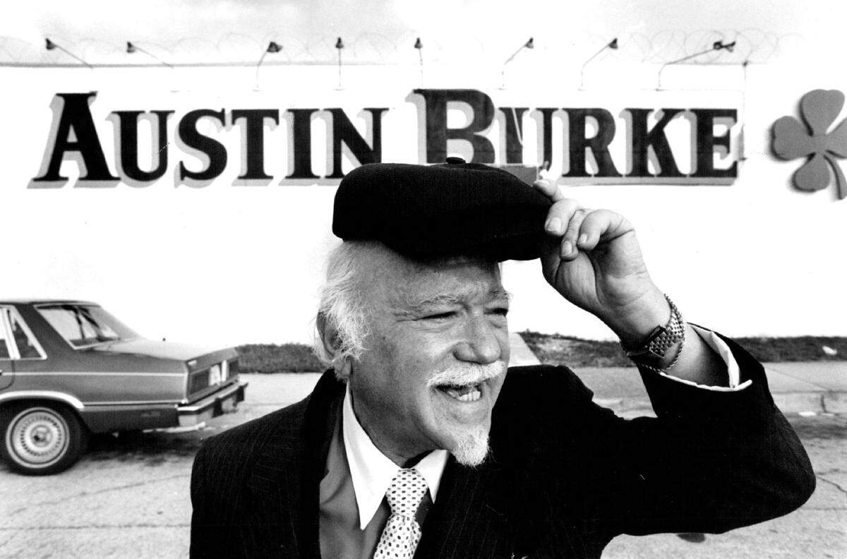 Austin Burke in an undated file photo in front of his namesake Miami clothing store and its green shamrock was famed for his exhortations on TV commercials, “Li’l Ole Burkie’ll fit ya personally! Calling All Men! Calling All Men!” Burke died in 1987 but his shop has remained open for some 70 years. His son announced it will close at the end of January 2025.