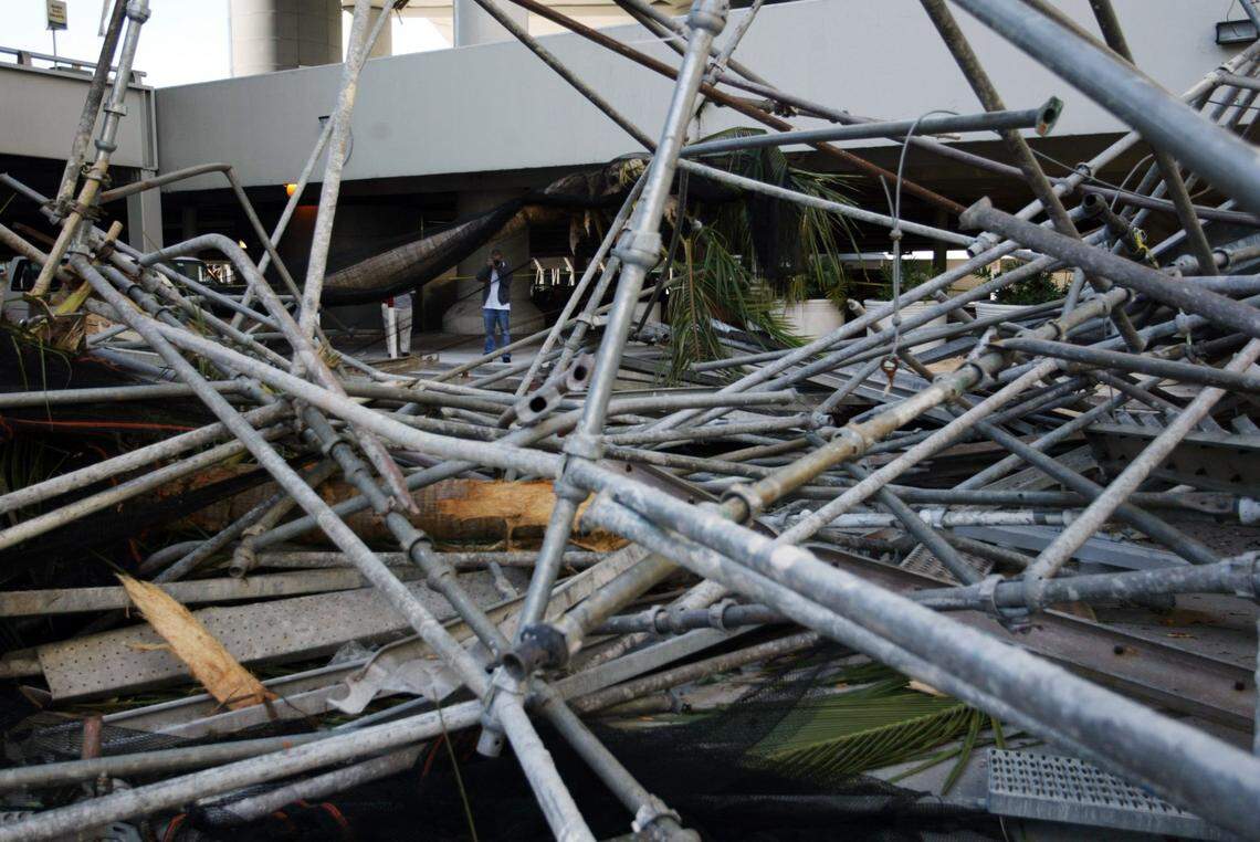 Workers at Miami International Airport look at scaffolding that fell off the parking garages during Hurricane Wilma.