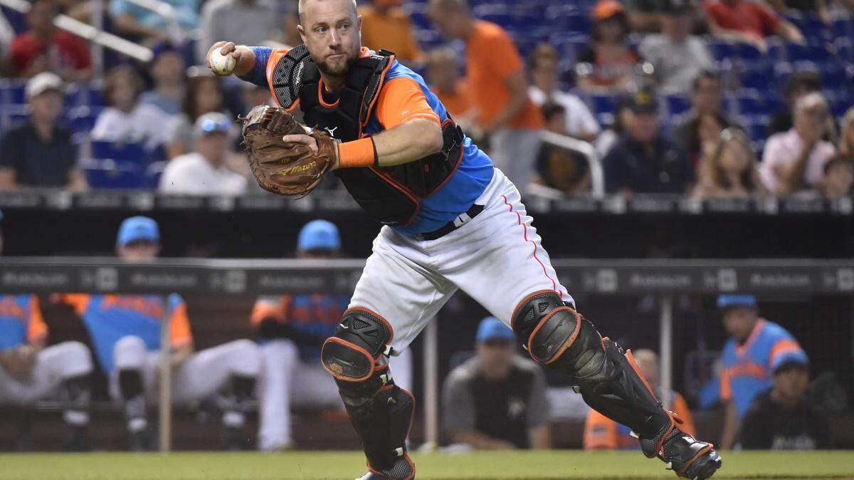 MIAMI, FL - AUGUST 26: Bryan Holaday #28 of the Miami Marlins throws towards first base during the fifth inning against the Atlanta Braves at Marlins Park on August 26, 2018 in Miami, Florida. All players across MLB will wear nicknames on their backs as well as colorful, non-traditional uniforms featuring alternate designs inspired by youth-league uniforms during Players Weekend. (Photo by Eric Espada/Getty Images)