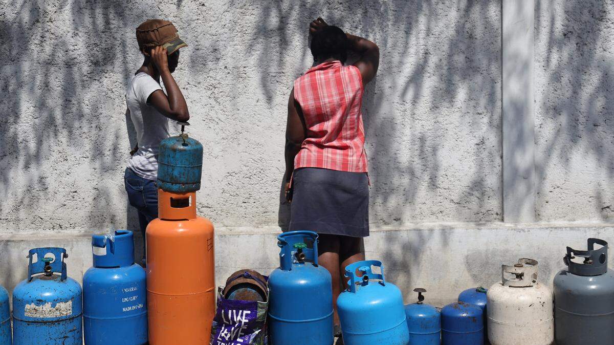 Two women stand among empty propane tanks used to mark the owners’ places in line. During violent protests that shut down the county for 10 days in February 2019, Port-au-Prince residents were forced to endure long lines for fuel, as well as water, throughout the capital city.