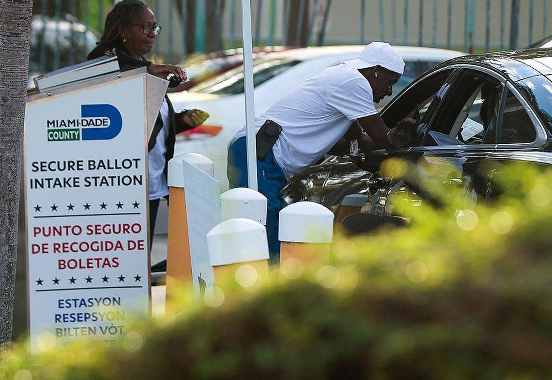 Poll workers assist a motorist in casting her ballot. On Monday, Oct. 24, 2022. Miami residents voted at the Lemon City Library in Miami during the first day of early voting in Miami-Dade County, Florida.