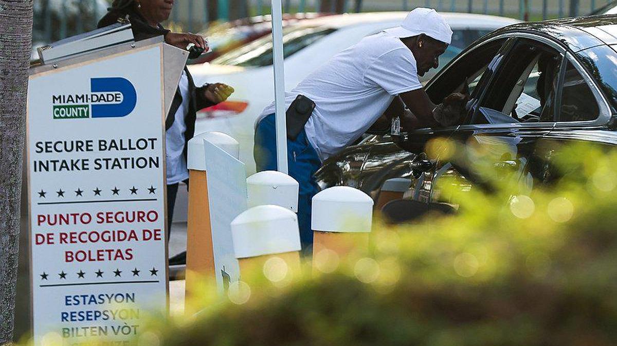 Trabajadores electorales ayudan a una automovilista a emitir su voto. El lunes 24 de octubre, 2022 habitantes de Miami emitieron su voto durante el primer día de votación anticipada en Miami-Dade en la Biblicte Municipal de Lemon City en Miami, Florida.
