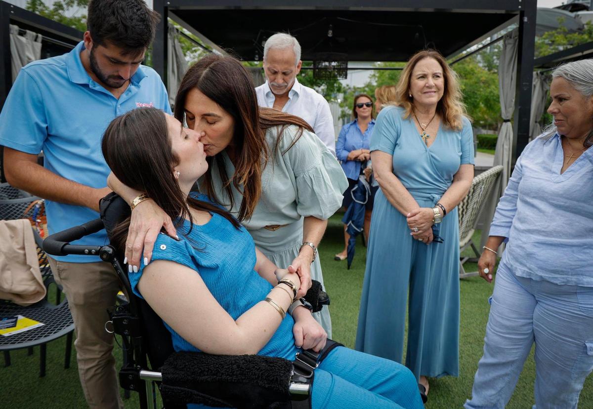 Boating accident survivor Katerina “Katy” Puig receives a hug and kiss from her mother Kathya Puig at an event commemorating the July 1, 2025, enactment of Lucy’s Law, a new state law that toughens penalties in boat accidents with serious injuries, Bayshore Club in Miami, Florida, on Wednesday, July 2, 2025.