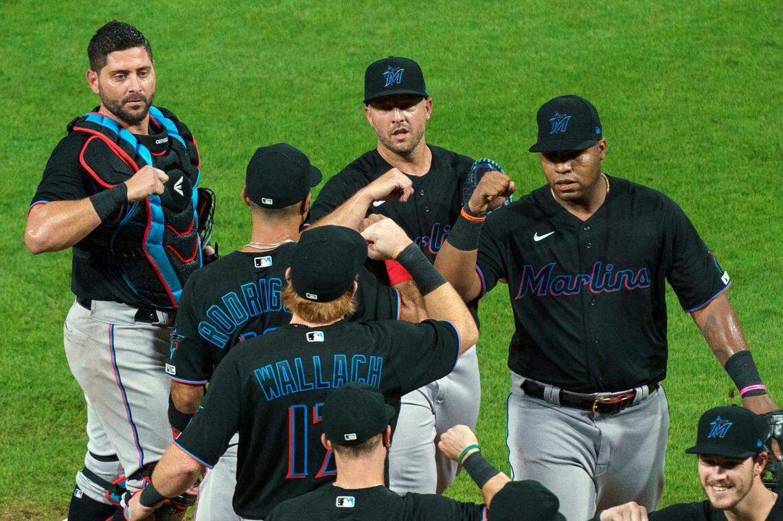 FILE - In this Friday, July 24, 2020, file photo, Miami Marlins’ Jesus Aguilar, right, celebrates a 5-2 win with teammates following a baseball game against the Philadelphia Phillies in Philadelphia. The Marlins’ coronavirus outbreak could endanger the Major League Baseball season, Dr. Anthony Fauci said, as the number of their players testing positive rose to 15. The Marlins received positive test results for four additional players Tuesday, July 23, 2020, a person familiar with the situation told The Associated Press. (AP Photo/Chris Szagola, File)