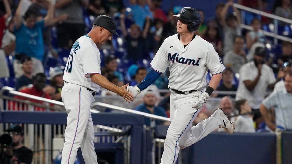 Miami Marlins Garrett Cooper is congratulated by third base coach Al Pedrique (13) after hitting a home run in the sixth inning of a baseball game against the San Francisco Giants, Sunday, June 5, 2022, in Miami. (AP Photo/Marta Lavandier)