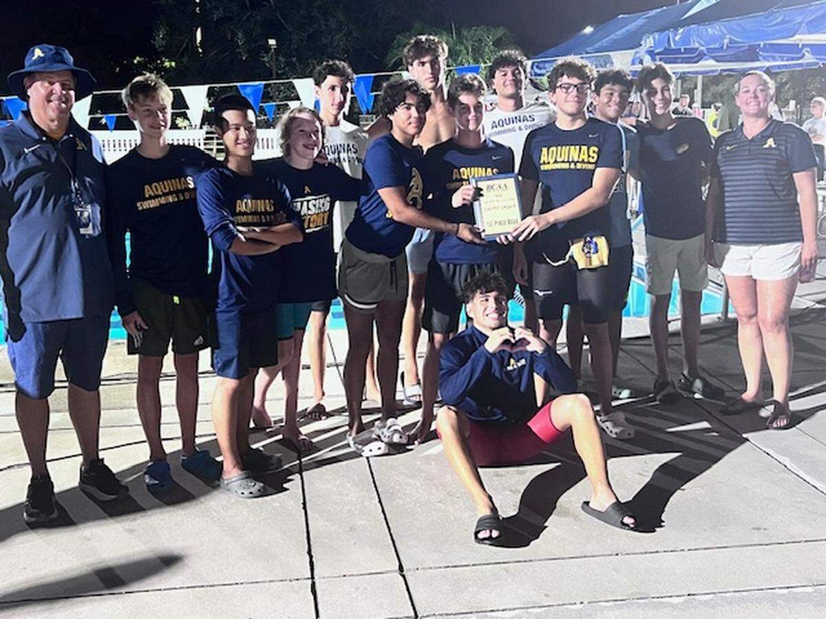 The St. Thomas Aquinas boys’ swimming and diving team celebrates after winning the BCAA championship on Saturday night at the Plantation Aquatic Center.