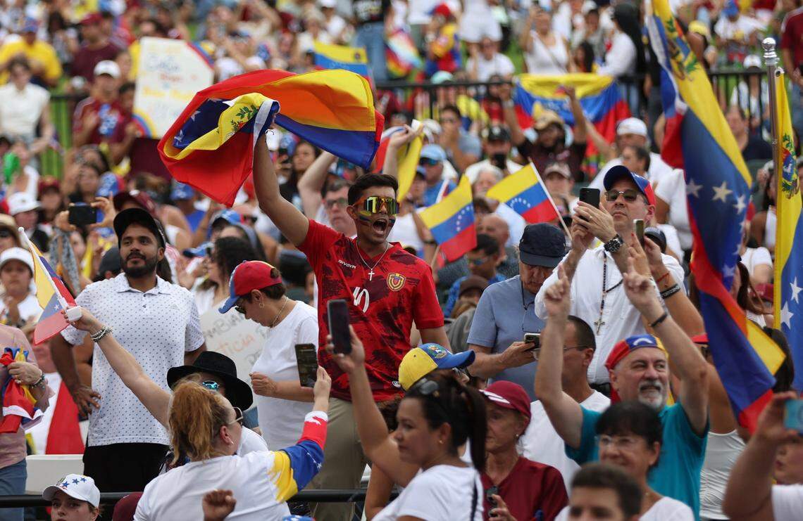 Waving Venezuelan flags, people chant during the rally at Bayfront Park.