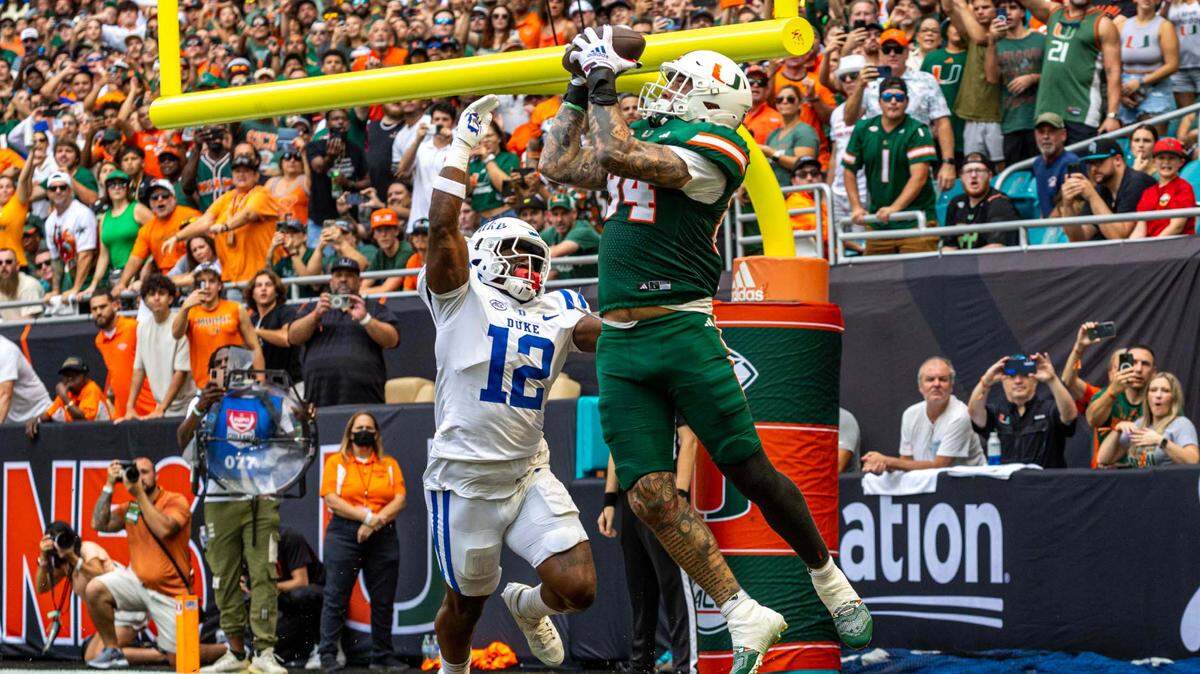 Miami Hurricanes tight end Cam McCormick (84) makes a catch for a touchdown as Duke Blue Devils linebacker Tre Freeman (12) looks on during the first half of an ACC football game at Hard Rock Stadium on Saturday, Nov. 2, 2024, in Miami Gardens, Fla.