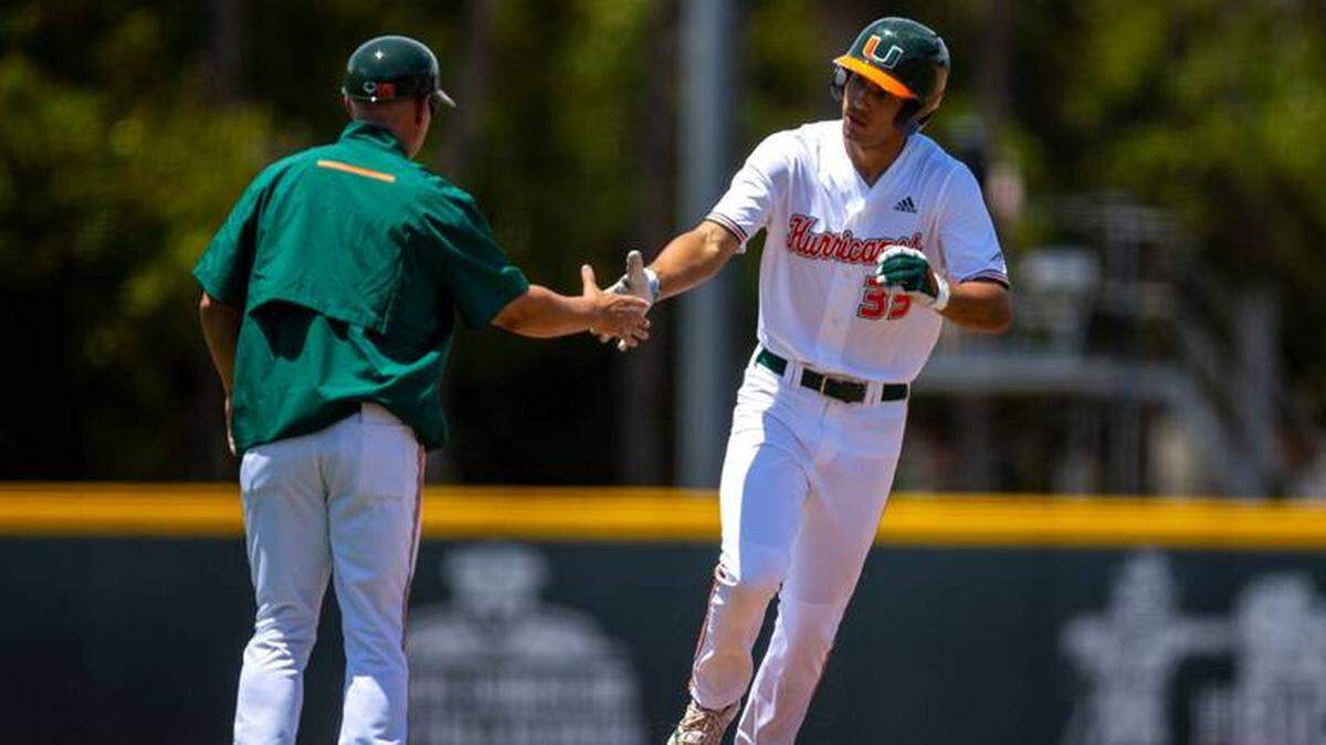 Miami Hurricane Yohandy Morales is congratulated by coach Gino DiMare after hitting a solo home run on Sunday, April 24, 2022 against Pittsburgh.