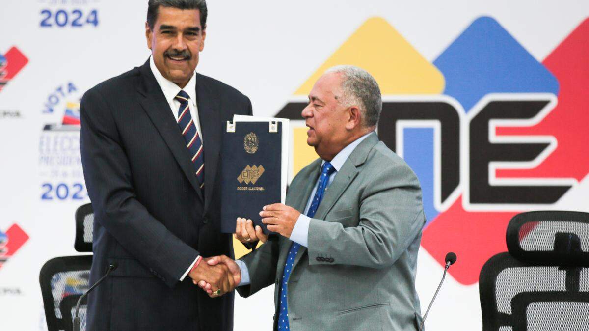 Venezuelan President Nicolas Maduro shakes hands with Elvis Amoroso, president of National Electoral Council