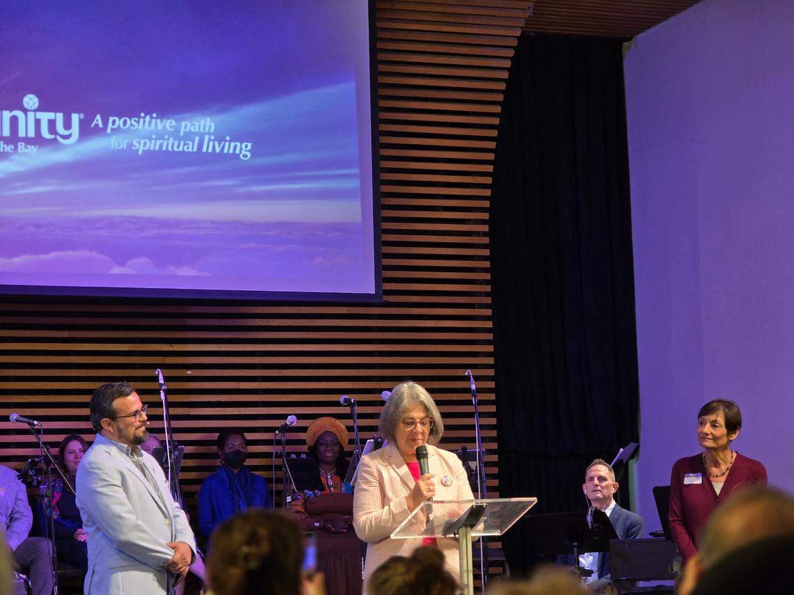 Miami-Dade County mayor Daniella Levine Cava spoke at an interfaith service in Miami aimed at building bridges and bring together people of different faith traditions. Rev. Juan del Hierro, senior minister at Unity on the Bay and Joanne Koren accompany her on stage.
