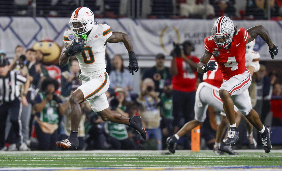 Miami Hurricanes defensive back Keionte Scott (0) intercepts the ball as Ohio State Buckeyes wide receiver Jeremiah Smith (4) gives chase during the first half of the College Football Playoff quarterfinal game in the Cotton Bowl at AT&T Stadium in Arlington, Texas on Wednesday, December 31, 2025.