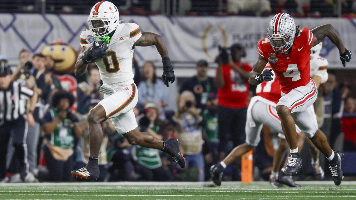 Miami Hurricanes defensive back Keionte Scott (0) intercepts the ball as Ohio State Buckeyes wide receiver Jeremiah Smith (4) gives chase during the first half of the College Football Playoff quarterfinal game in the Cotton Bowl at AT&T Stadium in Arlington, Texas on Wednesday, December 31, 2025.