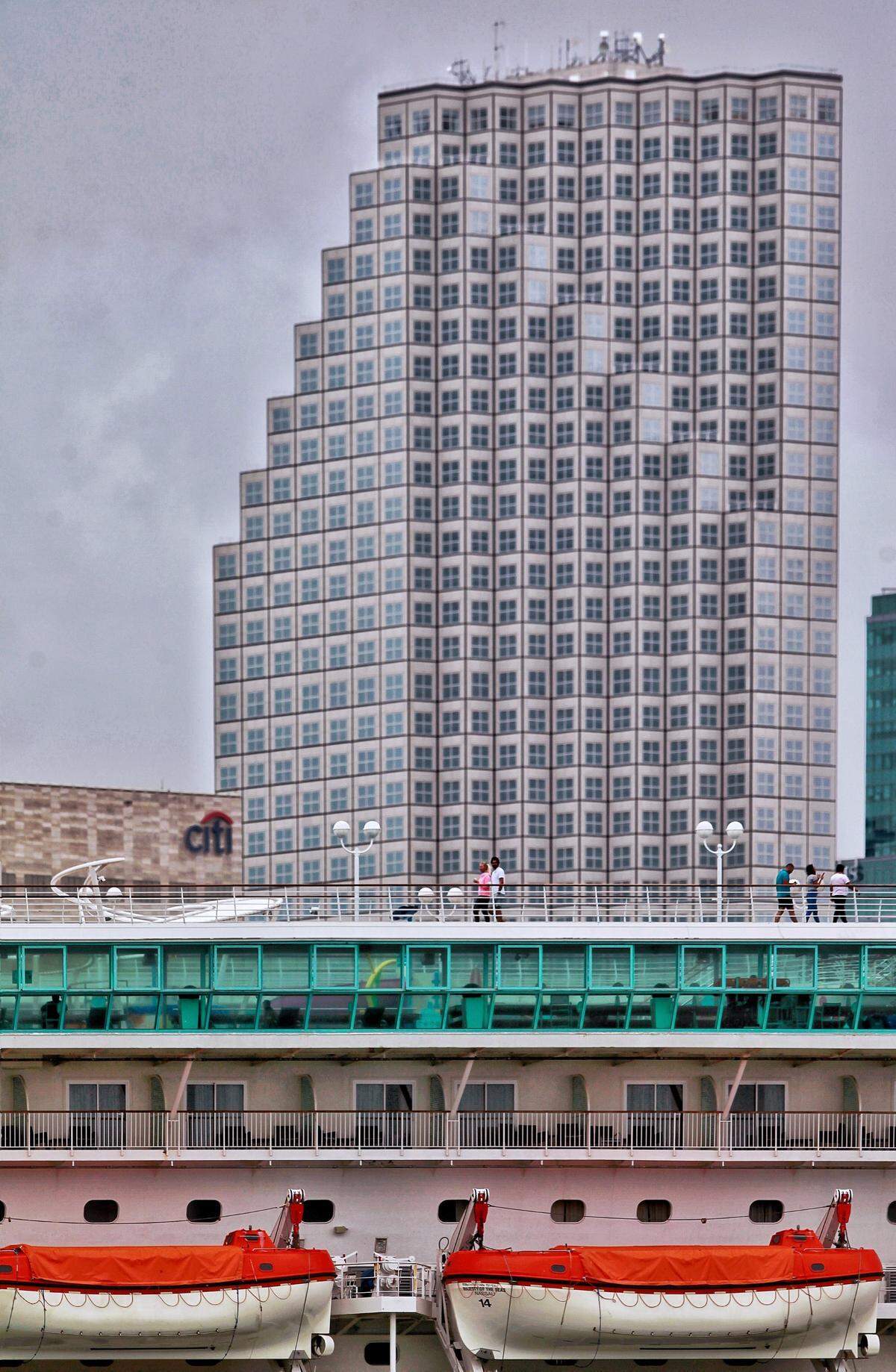 Under gray skies crew members walk the upper deck of Royal Caribbean’s Majesty of the Seas cruise ship docked at PortMiami on Thursday, May 14, 2020.