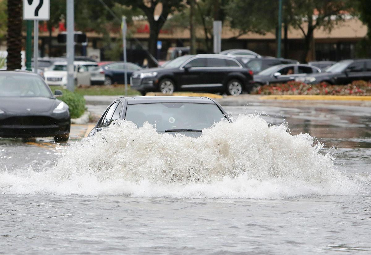 A car “swims” through flooded NE 29th Pl in Aventura on Monday, Dec. 23, 2019. Various streets in Aventura were flooded because of the heavy rain, resulting in traffic jams and stalled cars