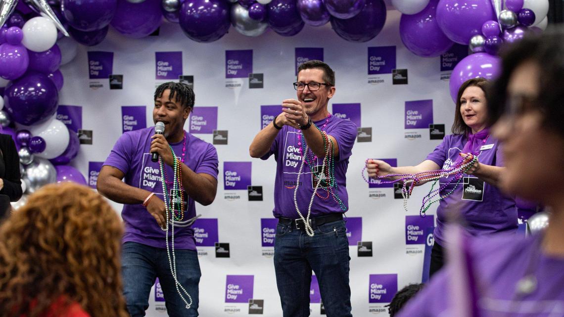 People throw necklaces while dancing during Give Miami Day at Miami Dade College’s Wolfson campus in Miami, Florida on Thursday, November 17, 2022.