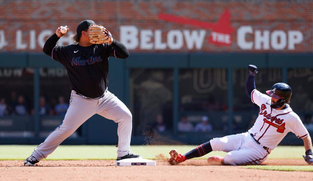 Atlanta Braves’ Dansby Swanson, right, cannot break up the double play as Miami Marlins’ Willians Astudillo, lefft, closes out the first inning with a throw to first in a baseball game on Saturday, May 28, 2022, in Atlanta. (AP Photo/Bob Andres)