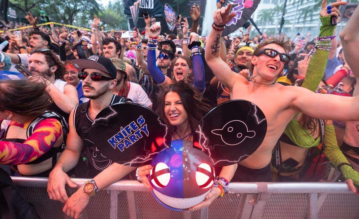 Kenzy, center, and Dean Stephens, right, dance on the Worldwide Stage Ultra Music Festival’s 25th anniversary at Bayfront Park on Saturday, March 29, 2025, in downtown Miami, Fla.