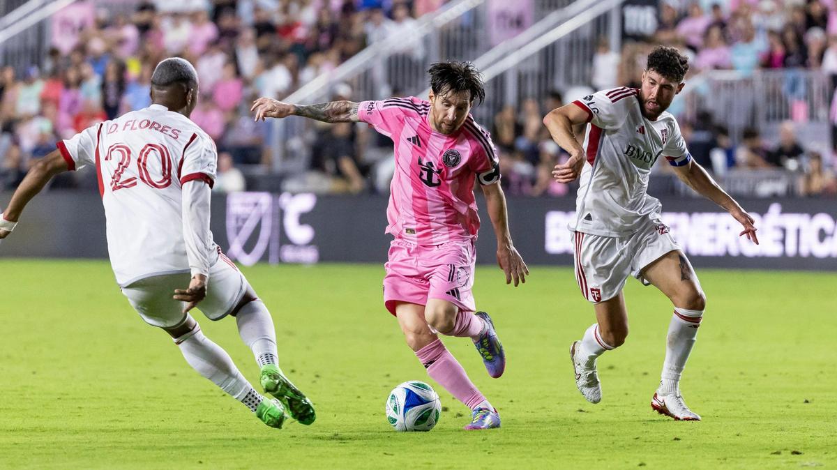 Inter Miami forward Lionel Messi (10) runs with the ball as Toronto FC midfielder Deybi Flores (20) defends in the first half of their MLS match at Chase Stadium on Sunday, April 6, 2025, in Fort Lauderdale, Fla.