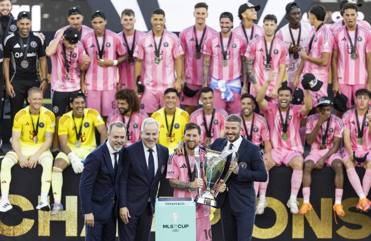 Inter Miami co-owners Jose Mas, Jorge Mas and David Beckham take a group photo with the Philip F. Anschutz Trophy after winning their MLS Cup final match against Vancouver Whitecaps at Chase Stadium on Saturday, Dec. 6, 2025, in Fort Lauderdale, Fla.