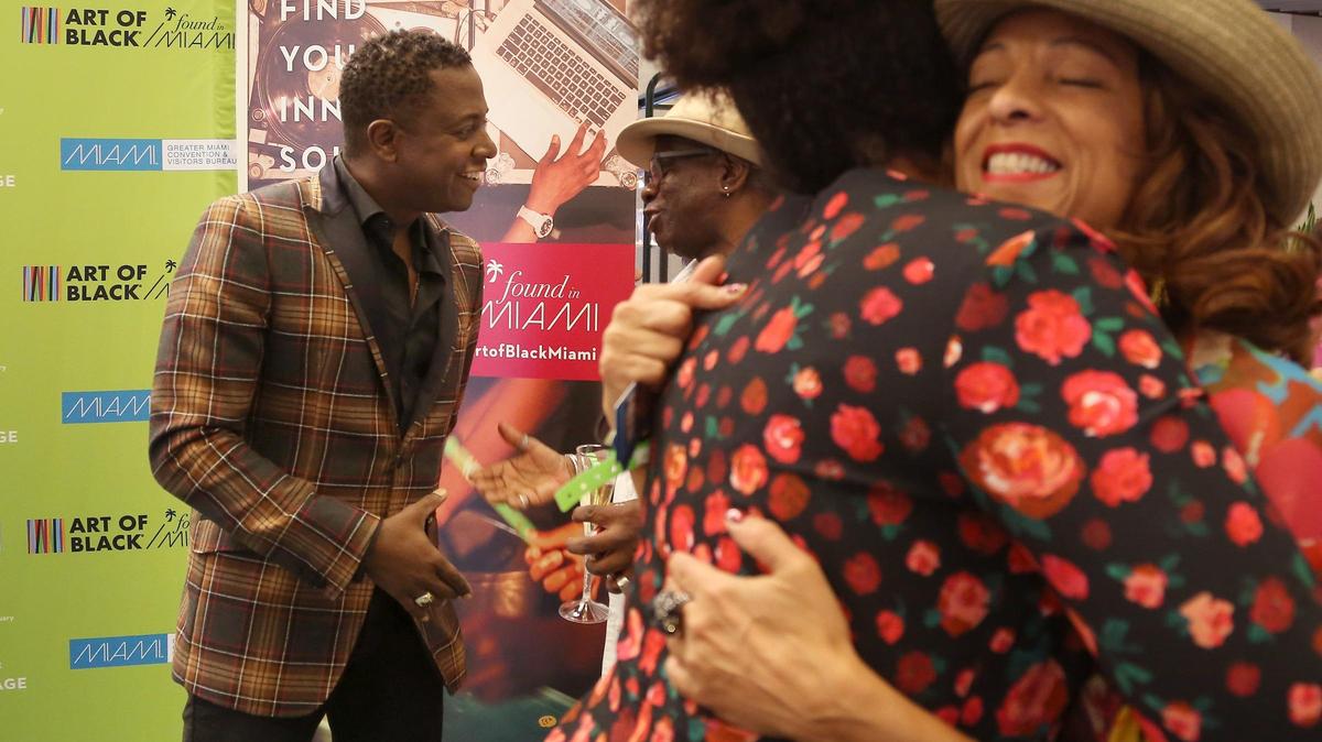 Polymathic artist Sanford Biggers, left, greets attendees during the Art of Black Miami event inside the Brightline Central Station in Overtown on Thursday, November 8, 2018. Art of Black Miami is a marketing platform and destination driver organized by the Greater Miami Convention & Visitors Bureau.