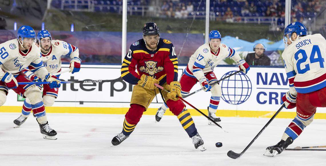 Florida Panthers left wing A.J. Greer (10) and New York Rangers defenseman Carson Soucy (24) compete for the puck in the third period of their Winter Classic outdoor hockey game at loanDepot park on Friday, Jan. 2, 2026, in Miami, Fla.