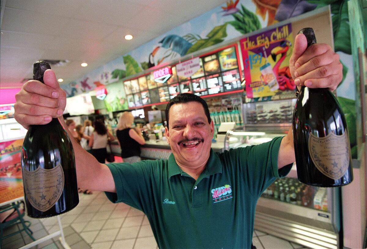 Romer Villalobos with bottles of Don Perignon at Miami Subs.