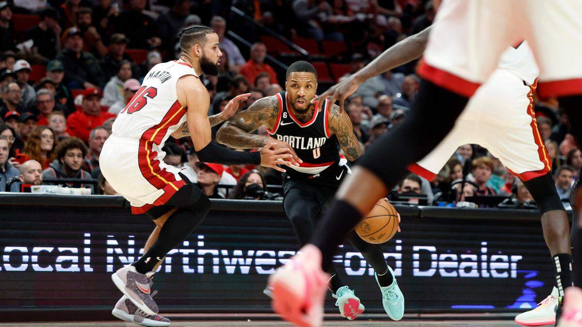 Portland Trail Blazers point guard Damian Lillard (0) dribbles the ball while defended by Miami Heat small forward Caleb Martin (16) during the first half at Moda Center.