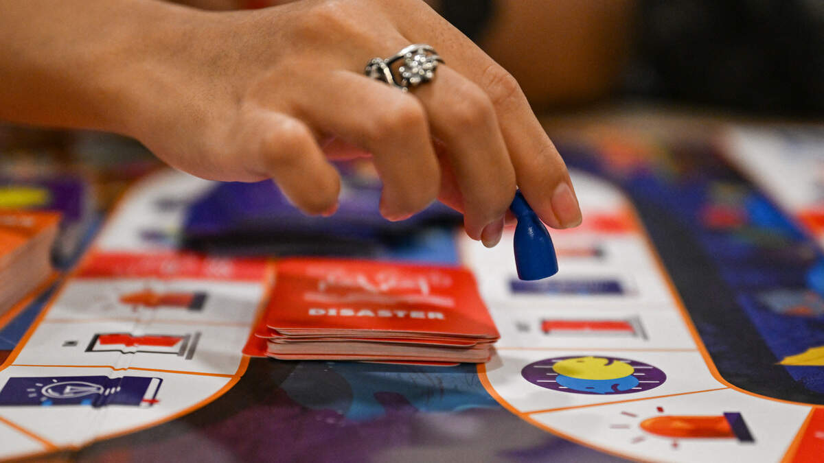 This photo taken on December 9, 2025, shows participants playing Master of Disaster, a board game about disaster preparedness, at a library in Valenzuela, Metro Manila.