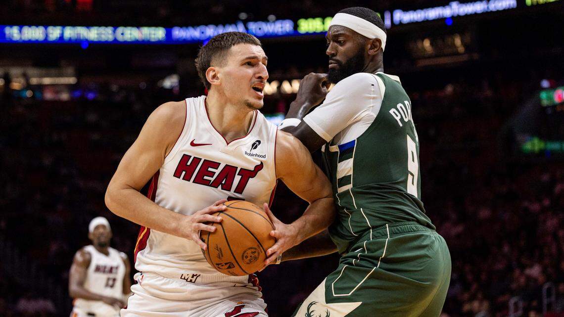 Miami Heat forward Nikola Jovic (5) drives on Milwaukee Bucks forward Bobby Portis (9) during the first half of an preseason NBA game at Kaseya Center on October  6, 2025, in Miami.